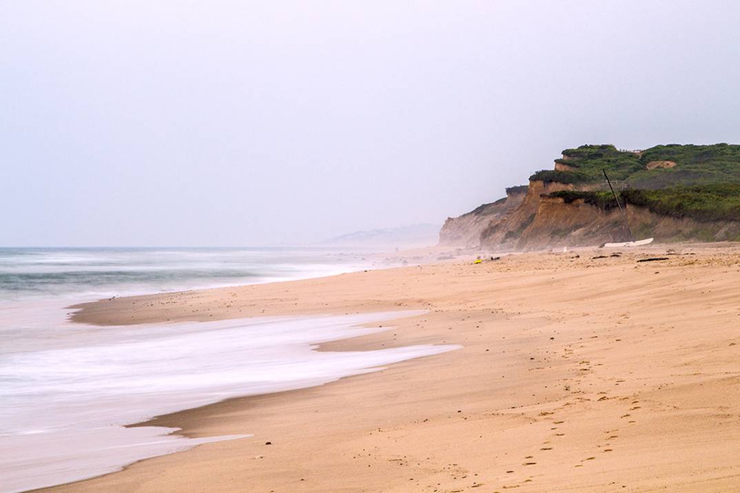 Ditch Plains Beach in Montauk with surfers waiting for waves and open sand