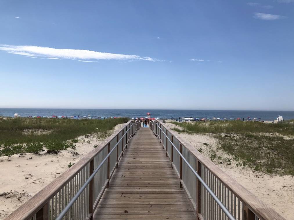 Ponquogue Beach in Hampton Bays with wide sand and a jetty in the distance