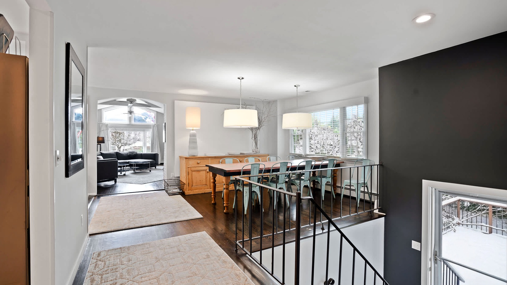 Dining table for ten under pendant lights, with snow outside the windows, at the Southampton 5BR in Southampton, NY
