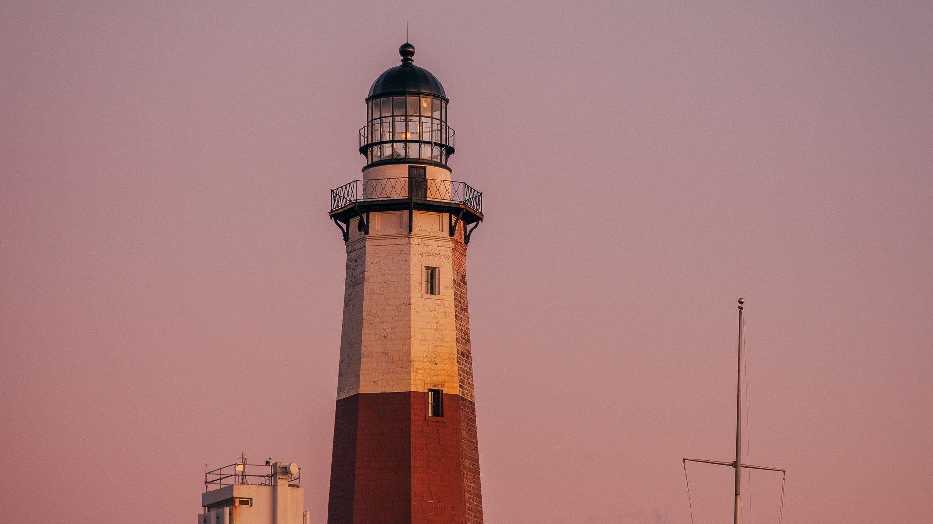 Montauk Point Lighthouse at dusk under a pink sky